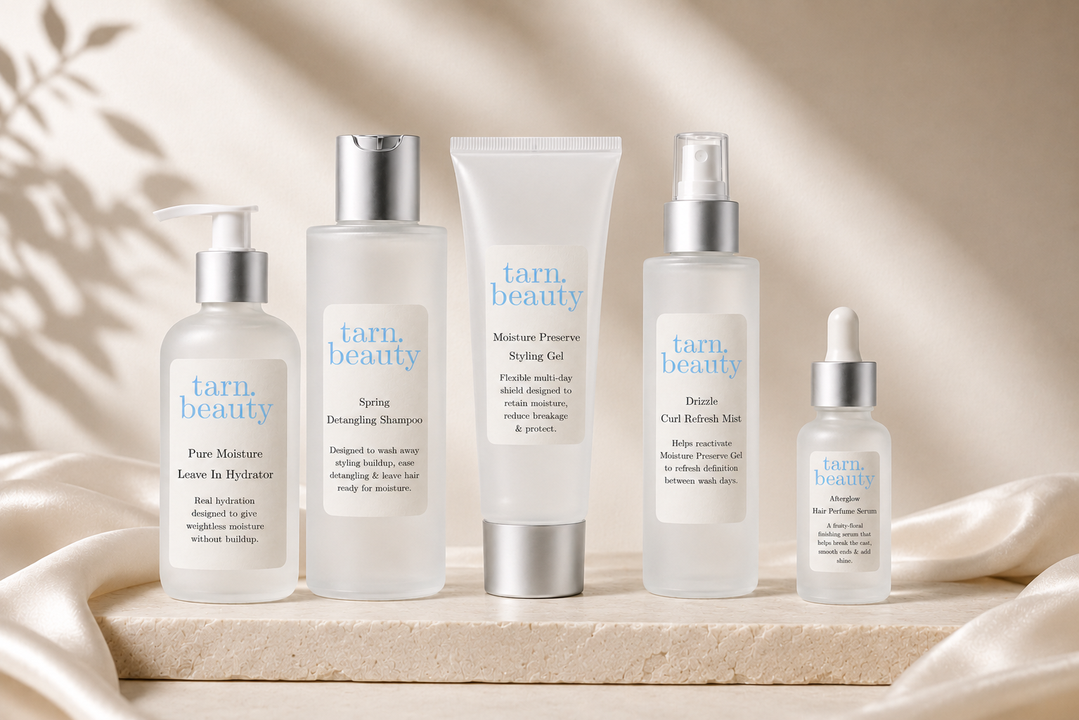 Tarn Beauty curl-care collection arranged on a warm ivory pedestal with satin draping